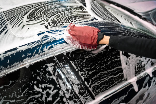Hand washing a foam-covered car with a microfiber wash mitt during a mobile exterior detail in Springfield, MO